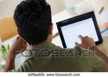 Stock Image - Male office worker using touchscreen on digital tablet. Fotosearch