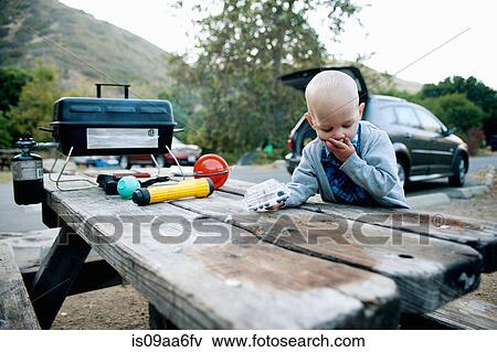 Stock Photo - Male toddler eating blueberries at picnic table. Fotosearch