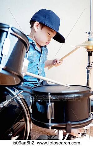 Stock Image - Male toddler playing drum kit. Fotosearch