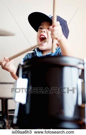 Stock Image - Male toddler playing on drum. Fotosearch