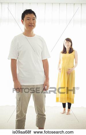Man with pregnant woman in background, portrait View Large Photo Image Stock Image - Man with pregnant woman in background, portrait. Fotosearch