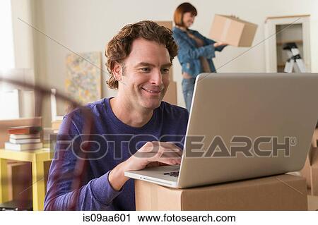 Mature man using computer whilst moving house View Large Photo Image Stock Image - Mature man using computer whilst moving house. Fotosearch
