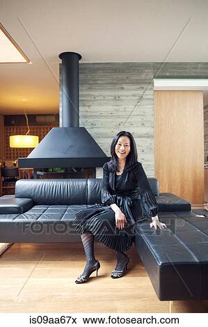 Stock Photo - Mature woman sitting on sofa, portrait. Fotosearch