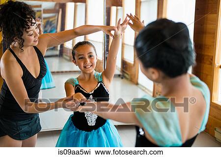 Stock Image - Mature woman teaching ballerinas. Fotosearch