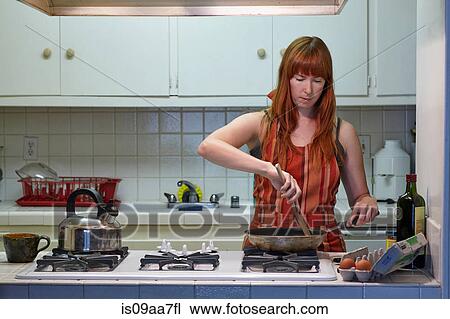 Mid adult woman cooking in kitchen View Large Photo Image Stock Image - Mid adult woman cooking in kitchen. Fotosearch