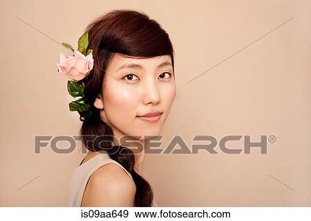 Mid adult woman wearing flower in hair, portrait View Large Photo Image Stock Photo - Mid adult woman wearing flower in hair, portrait. Fotosearch
