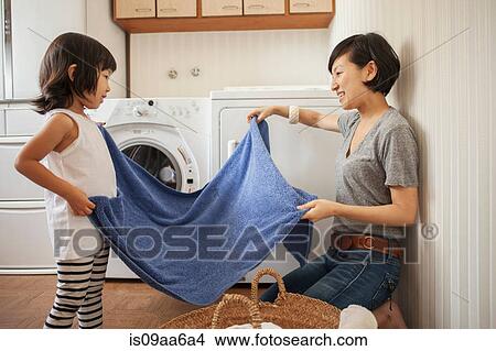 Mother and daughter folding towel View Large Photo Image Picture - Mother and daughter folding towel. Fotosearch