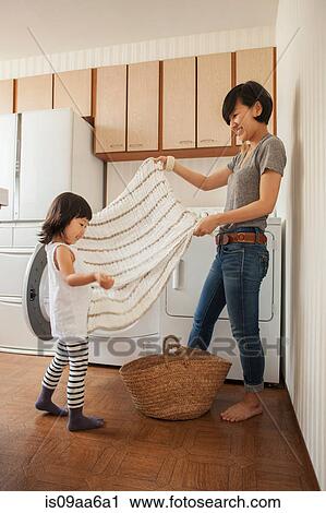 Mother and daughter folding towel View Large Photo Image Stock Image - Mother and daughter folding towel. Fotosearch
