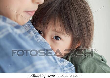 Stock Image - Mother and son hugging, close up portrait. Fotosearch