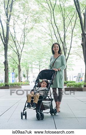Stock Image - Mother with son sitting in stroller, portrait. Fotosearch
