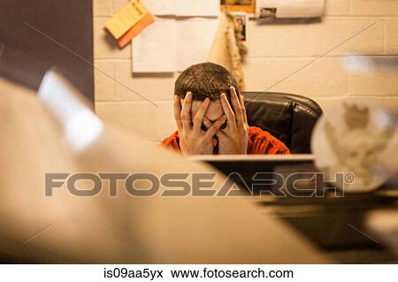 Stock Photo - Overworked business owner sitting in warehouse office. Fotosearch