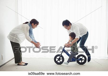 Parents with son learning to ride bicycle View Large Photo Image Stock Image - Parents with son learning to ride bicycle. Fotosearch