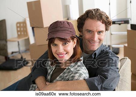 Stock Photo - Portrait of couple resting on chair whilst moving home. Fotosearch