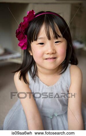 Stock Image - Portrait of girl with flower in hair, smiling. Fotosearch
