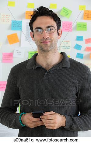 Portrait of male office worker holding mobile View Large Photo Image Stock Photography - Portrait of male office worker holding mobile. Fotosearch