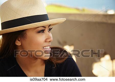 Portrait of smiling young woman wearing sunhat at coast View Large Photo Image Picture - Portrait of smiling young woman wearing sunhat at coast. Fotosearch