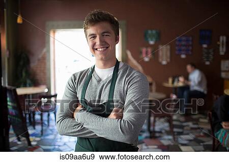 Stock Photo - Portrait of young waiter in coffee house. Fotosearch