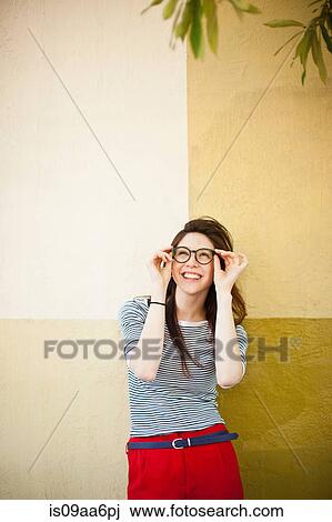 Stock Image - Portrait of young woman in front of color divided wall. Fotosearch