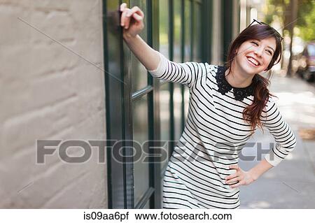 Stock Image - Portrait of young woman on sidewalk. Fotosearch