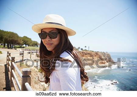 Stock Image - Portrait of young woman wearing sunhat, Palos Verdes, California, USA. Fotosearch