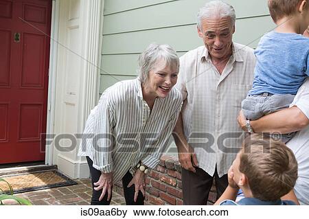 Stock Photo - Senior couple greeting family at home. Fotosearch