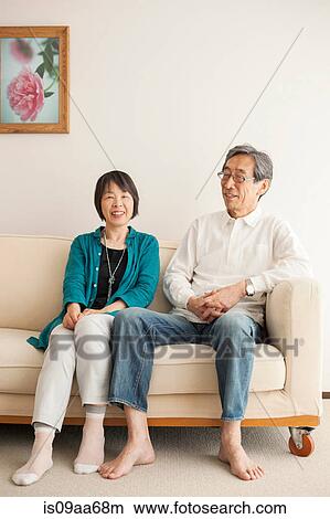 Senior couple sitting on sofa, portrait View Large Photo Image Picture - Senior couple sitting on sofa, portrait. Fotosearch