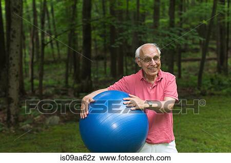 Senior man holding exercise ball, portrait View Large Photo Image Stock Photo - Senior man holding exercise ball, portrait. Fotosearch