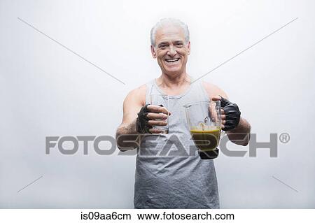 Senior man holding smoothie in blender, portrait View Large Photo Image Picture - Senior man holding smoothie in blender, portrait. Fotosearch