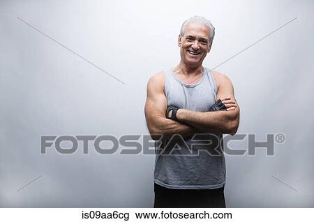 Stock Image - Senior man in sports clothing with arms crossed, portrait. Fotosearch