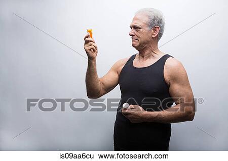 Senior man looking at pill bottles View Large Photo Image Stock Photograph - Senior man looking at pill bottles. Fotosearch