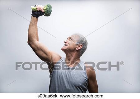 Senior man looking up and lifting broccoli View Large Photo Image Stock Image - Senior man looking up and lifting broccoli. Fotosearch