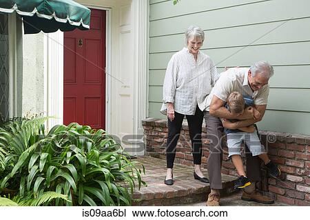 Senior man playing with grandson outside home View Large Photo Image Stock Image - Senior man playing with grandson outside home. Fotosearch