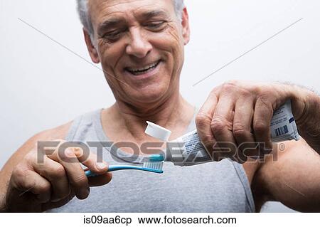 Senior man squeezing toothpaste onto brush View Large Photo Image Stock Photography - Senior man squeezing toothpaste onto brush. Fotosearch