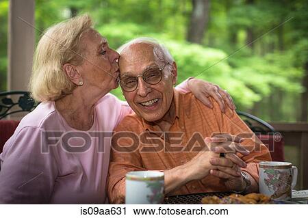Stock Image - Senior woman kissing man, smiling. Fotosearch