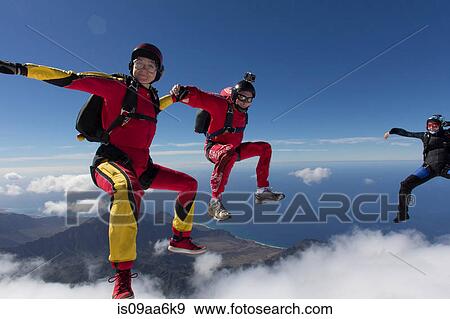 Small group of skydivers reaching to join hands View Large Photo Image Stock Photo - Small group of skydivers reaching to join hands. Fotosearch