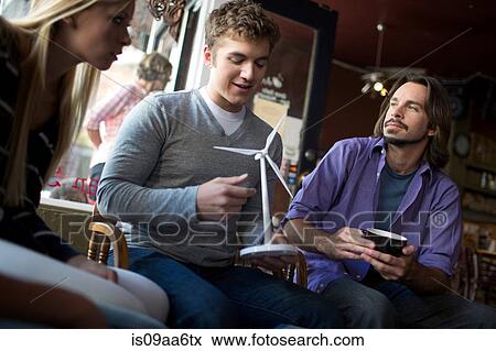 Stock Photo - Small study group looking at model in coffee house. Fotosearch