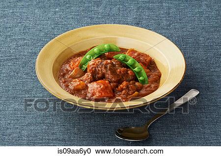 Stock Image - Still life of casserole garnished with pea pods. Fotosearch