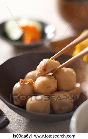 Stock Image - Still life of chopsticks picking up japanese dumpling. Fotosearch
