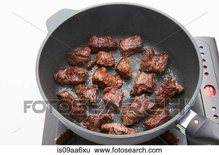Still life of meat frying in pan on hob View Large Photo Image Stock Photograph - Still life of meat frying in pan on hob. Fotosearch