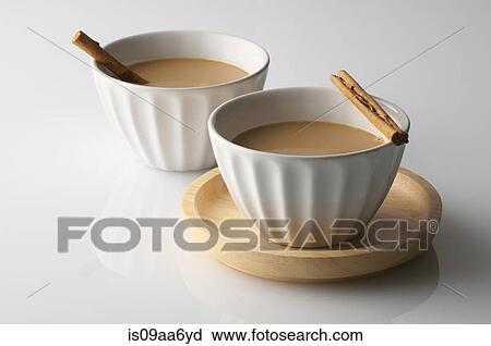 Stock Image - Still life of two bowls of drink with cinnamon sticks. Fotosearch