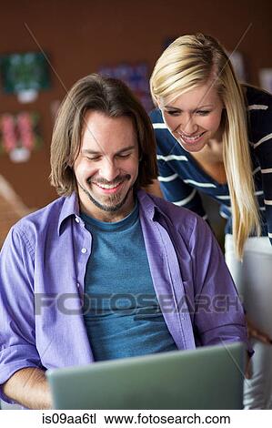 Stock Image - Teenage girl and mentor using at computer in cafe. Fotosearch