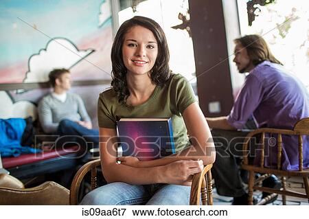 Teenager holding book in cafe View Large Photo Image Stock Photo - Teenager holding book in cafe. Fotosearch