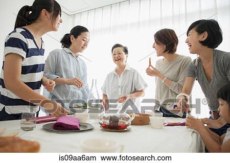 Three generation family laughing at mealtime View Large Photo Image Picture - Three generation family laughing at mealtime. Fotosearch