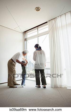 Three generation family standing by window View Large Photo Image Picture - Three generation family standing by window. Fotosearch