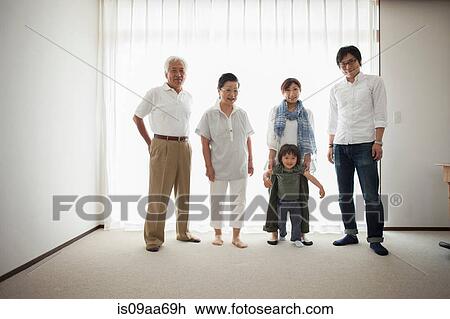 Stock Image - Three generation family standing by window, portrait. Fotosearch
