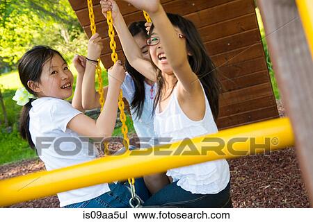 Three girls playing on swing View Large Photo Image Stock Image - Three girls playing on swing. Fotosearch