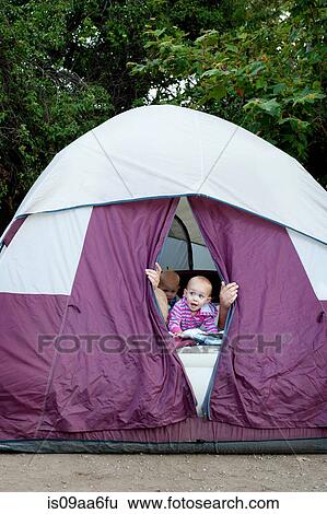 Stock Photograph - Toddler twins and father peeking out of tent. Fotosearch