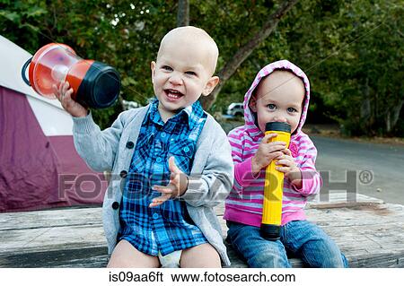 Toddler twins having fun sitting on picnic table View Large Photo Image Stock Photograph - Toddler twins having fun sitting on picnic table. Fotosearch