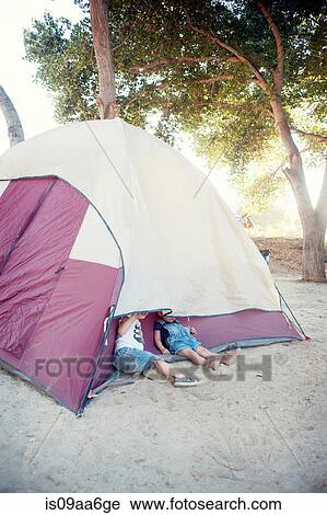 Stock Image - Toddler twins hiding under tent. Fotosearch