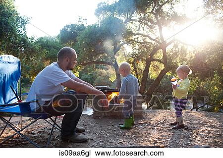 Stock Image - Toddler twins on camping site with father. Fotosearch